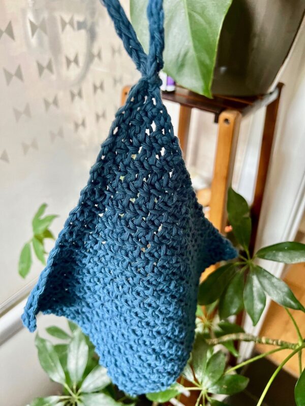 blue crochet moss stitch facial washcloth hanging in bathroom